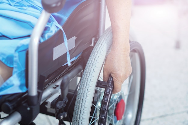 Asiatique senior ou âgée vieille femme patiente sur un fauteuil roulant électrique à l&#39;hôpital de soins infirmiers.