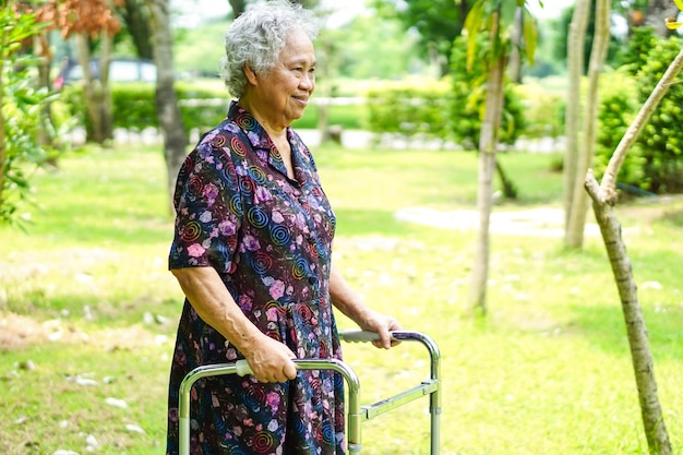 Asiatique senior ou âgée vieille femme patiente à pied avec walker dans le parc.