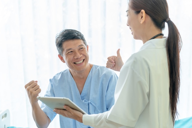 Asiatique senior patient sur un lit d'hôpital discuter avec une femme médecin