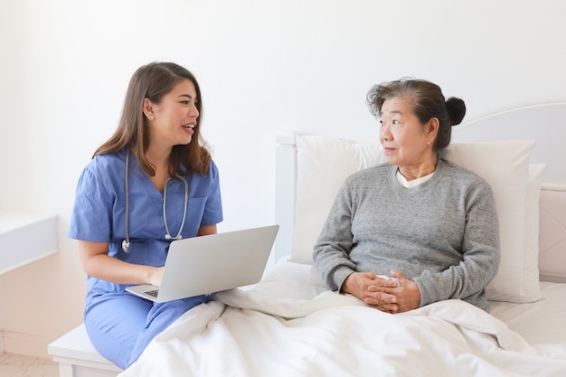 Asiatique vieille femme âgée sur le lit avec le médecin et son fils à l'hôpital