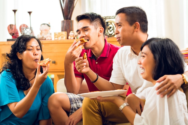 Asiatiques en train de manger une pizza à la fête