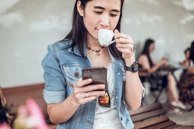 Asie femme assise dans le café et à l&#39;aide de téléphone portable