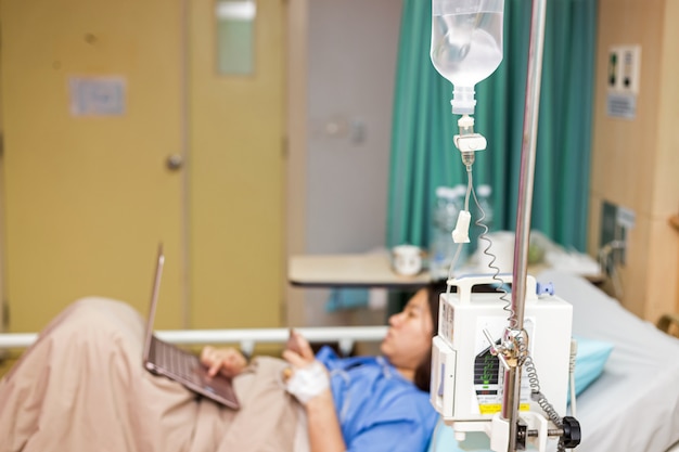 Asie femme patiente travaillant avec un ordinateur portable au cours de l&#39;hôpital