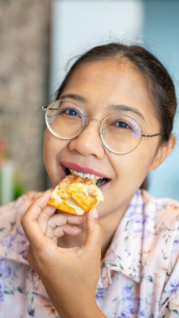 Asie Femme tenant une pizza italienne maison fraîche Margherita et une tranche de pizza chaude souriante