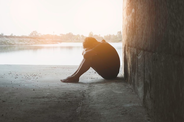 Asie vous homme assis seulIl est assis dans un homme des cavernes très triste et déprimésadalonesuicidedésespoirmaladiephoto concept de santé et de déception