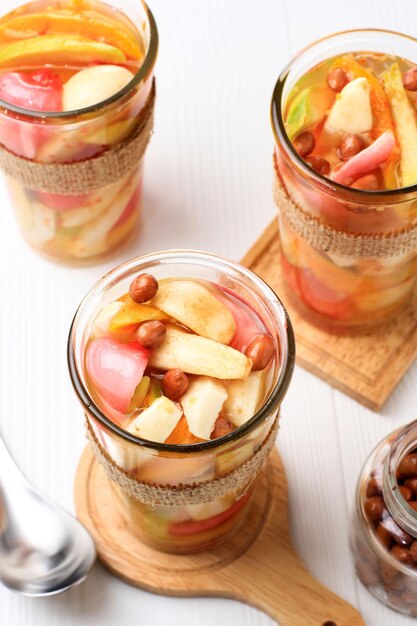 Asinan Bogor Cornichons aux fruits populaires avec des craquelins aux arachides et aux nouilles de Bogor West Java Servis sur un grand verre Angle Higj Fond en bois blanc