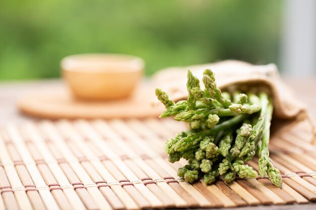 L'asperge est un légume vert et droit L'asperge verte fraîche est croustillante pour cuire sur une table en bois avec du sel