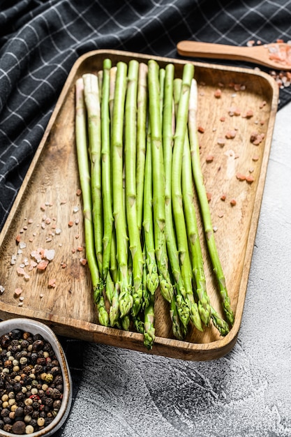 Asperges fraîches de bébé vert dans un bol en bois. Vue de dessus