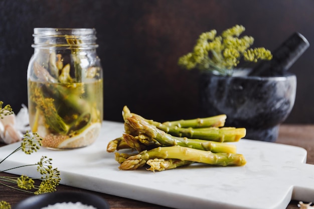 Asperges marinées sur un plateau en marbre blanc Recette de légumes de saison en conserve