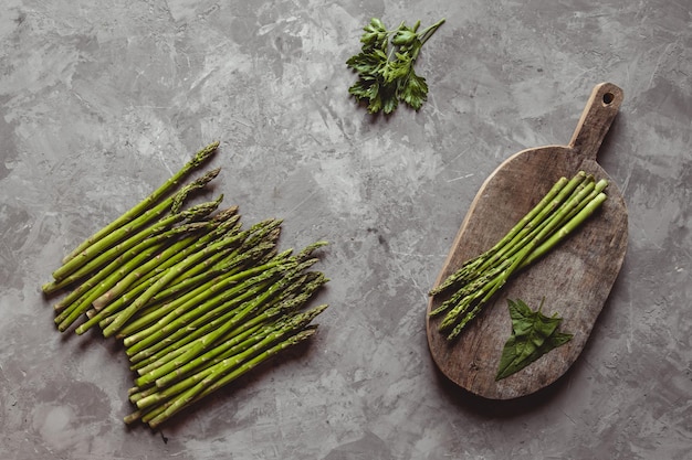 Asperges sur une planche à découper. Alimentation saine, santé sur un fond concret.