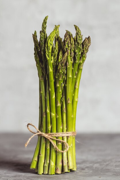 Asperges de printemps vertes fraîches sur un fond en bois. Saison des asperges