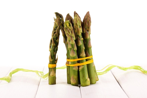 Asperges utiles sur table en bois sur fond blanc