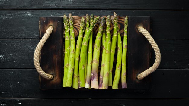 Asperges vertes Asperges fraîches sur fond noir Vue de dessus Espace libre pour votre texte