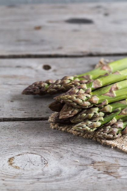 Asperges vertes. Bouquets d'asperges vertes sur fond rustique en bois gris