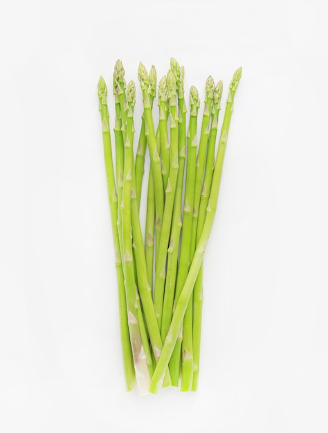 Asperges vertes fraîches sur fond blanc.