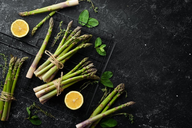 Asperges vertes fraîches sur fond de pierre noire Alimentation saine Vue de dessus espace de copie gratuit