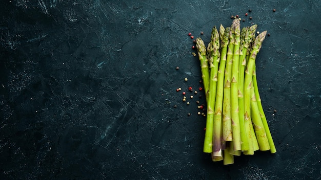 Asperges vertes fraîches sur fond de pierre noire Vue de dessus Espace libre pour votre texte