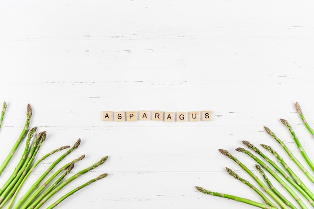 Asperges vertes fraîches sur une surface en bois blanche