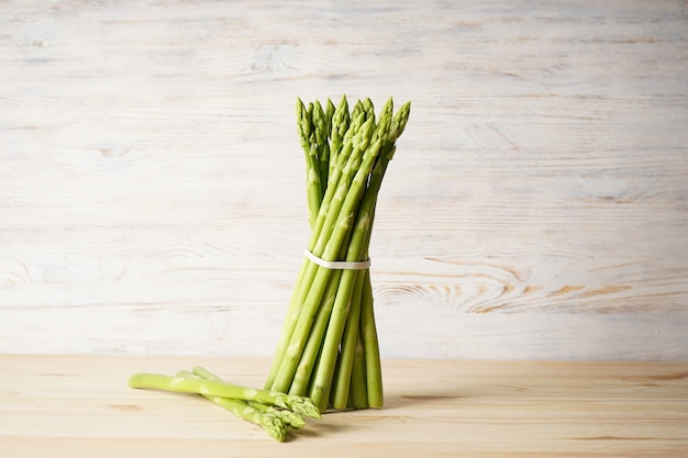 Asperges vertes fraîches sur une surface en bois.