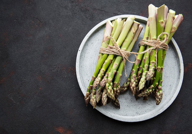 Asperges vertes fraîches sur table en béton noir. Mise à plat