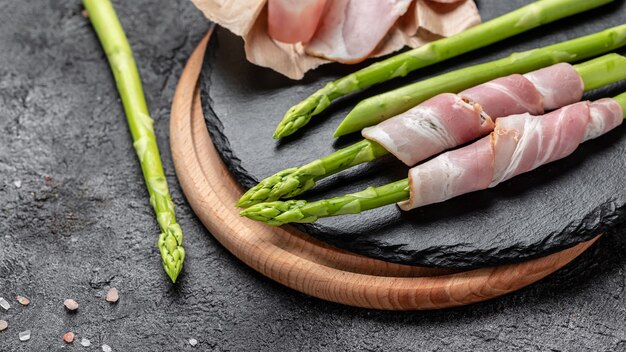 Asperges vertes grillées enveloppées de bacon sur une lèchefrite