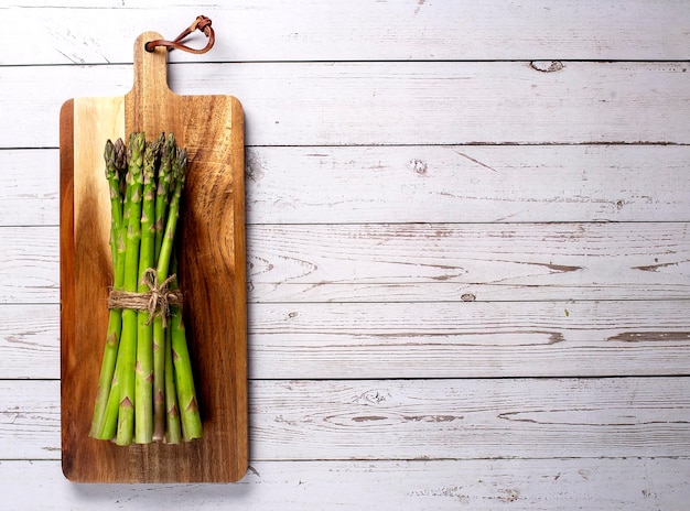 Asperges vertes sur planche de bois Vue de dessus mise à plat Copier l'espace