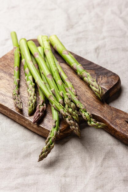 Des asperges vertes sur une planche à couper en bois