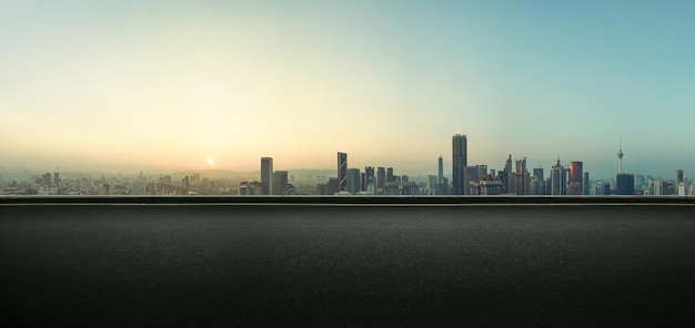 Photo asphalte vide sur le bord de la route avec l'horizon de la ville de kuala lumpur en arrière-plan scène du lever du soleil