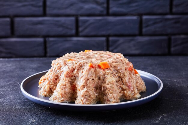 Aspic de viande en gelée de viande cuite lentement sur une assiette