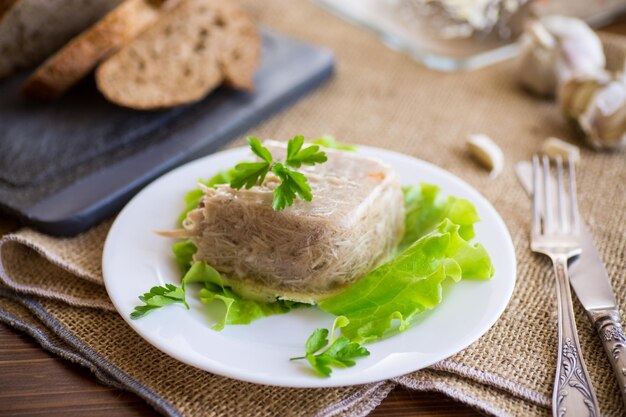 Aspic de viande de poulet bouilli dans un bouillon de gélatine de viande dans une assiette