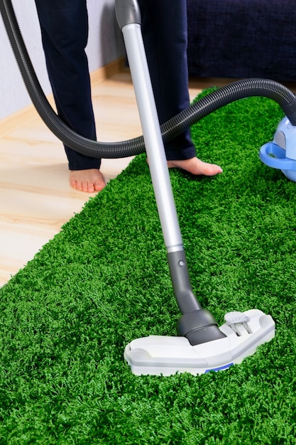 Aspirateur en action un homme nettoie un tapis