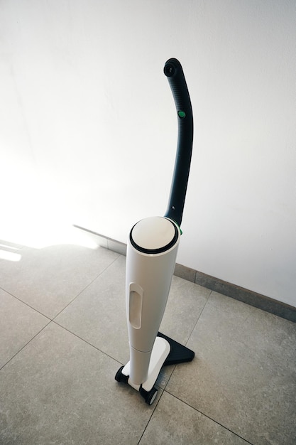 Un aspirateur blanc avec une lumière verte sur le dessus.