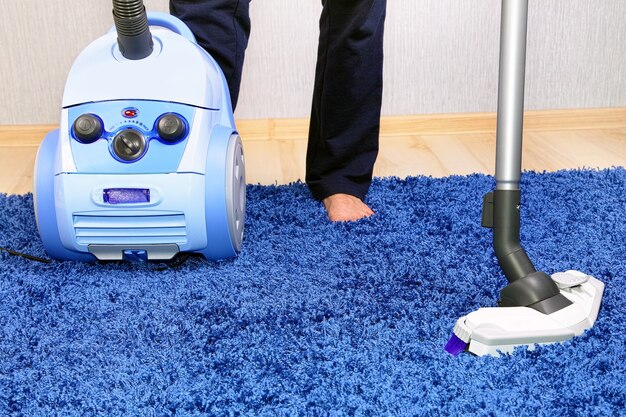 Aspirateur puissant en action-un homme nettoie un tapis.