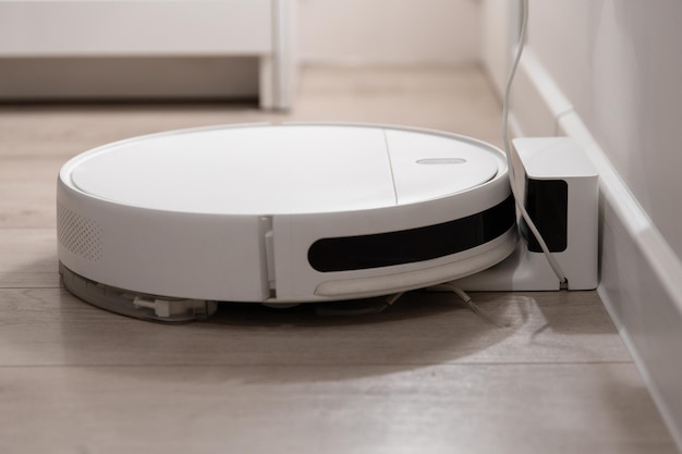 L'aspirateur robot blanc se tient à la station de charge