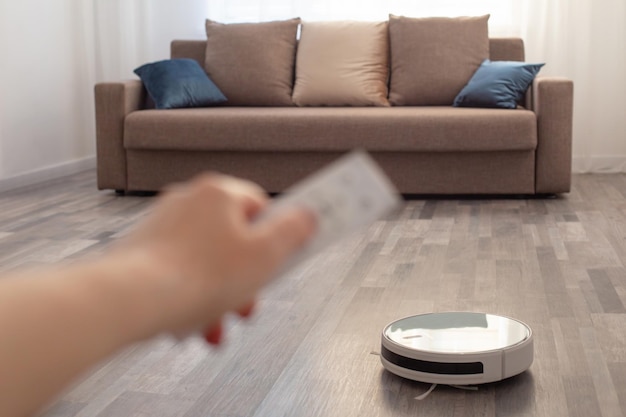 Aspirateur robot posé au sol dans le salon