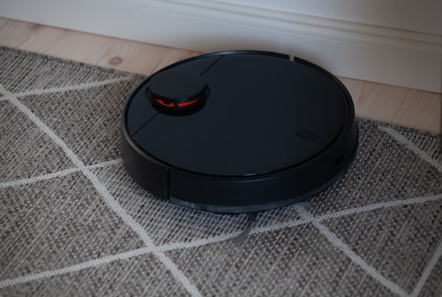 Aspirateur robotique nettoyant le tapis à la maison