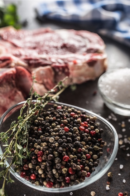 Assaisonner quatre sortes de pois poivrés dans un bol avec de la viande crue et des herbes.