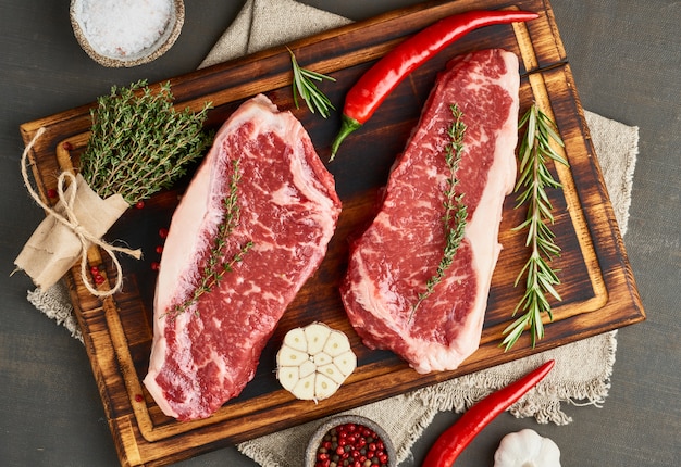 Assaisonner le steak cru avec du sel, du thym, de l'ail. Deux gros morceau entier de viande de boeuf crue