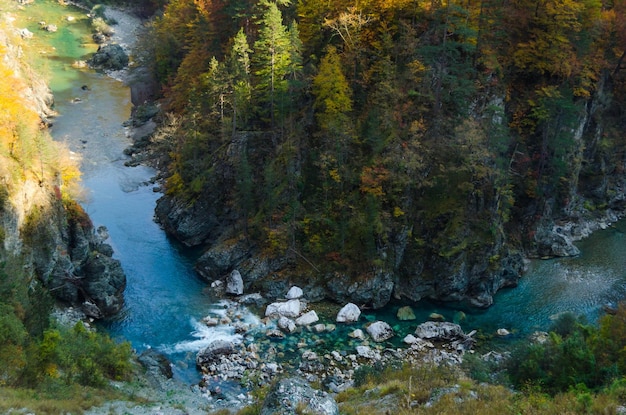 L'assèchement de la rivière bleue coule profondément dans le canyon contre la forêt d'automneNature et nature sauvage