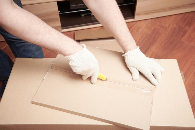 L'assembleur de meubles déballe la boîte avec étagère pour l'auto-assemblage Processus d'assemblage de meubles à la maison Assemblage de bricolage Vue rapprochée