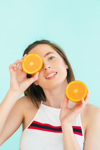 Assez charmante fille pure naturelle drôle gaie ayant deux morceaux d'orange