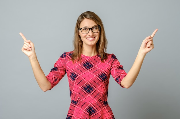 Assez gaie femme gesticulant avec les doigts et la main et montrant loin