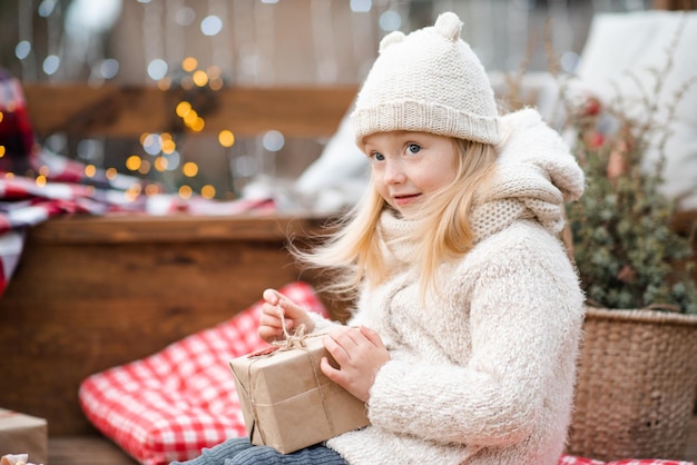 Assez mignon enfant fille 5-6 ans pack ou cadeau de Noël ouvert sur l'arbre de Noël en plein air