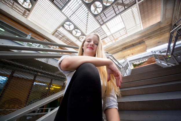 Assez souriante joyeusement femme aux cheveux blonds, habillée avec désinvolture.