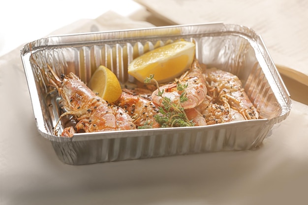 Assiette en aluminium avec de délicieuses crevettes grillées sur table