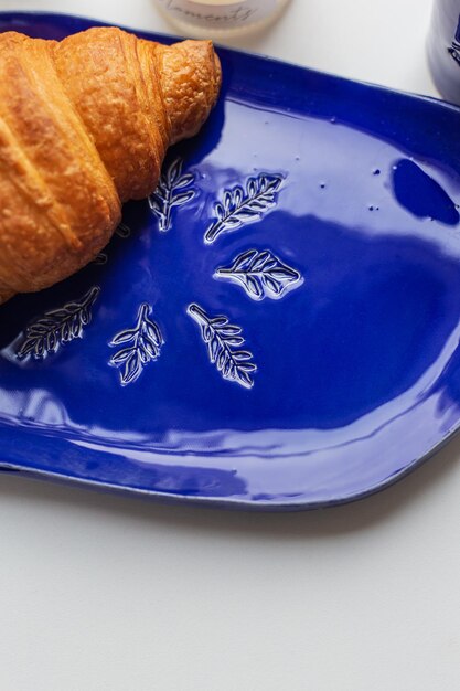 Assiette en argile bleue faite à la main avec un croissant dessus