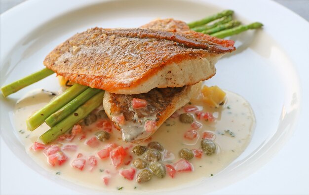 Assiette de bar poêlé avec sauce crème tomate câpres moutarde