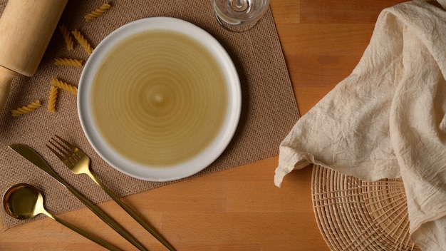 Assiette beige avec un chiffon sur une table en bois