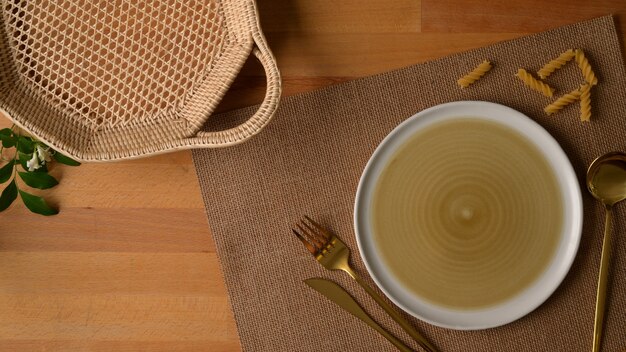 Assiette beige avec un chiffon sur une table en bois