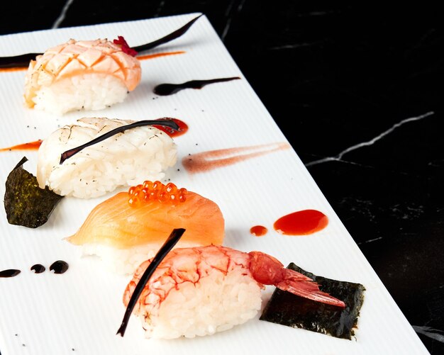Assiette blanche élégante de morceaux de sushi Nigiri Vue de face Concept alimentaire